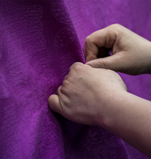 Hände auf einem violetten Stoff